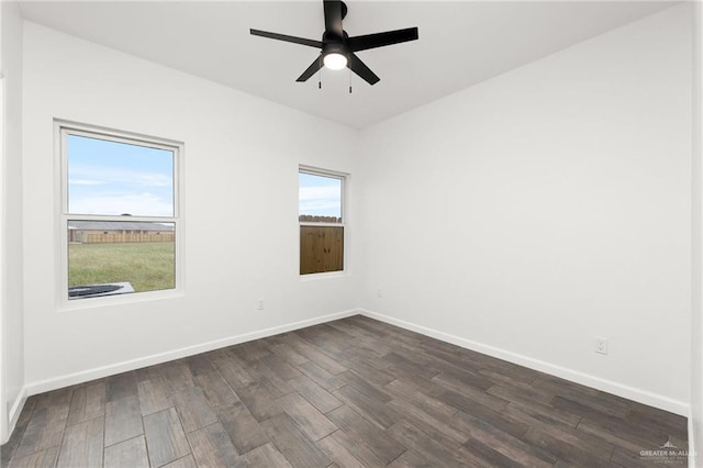 spare room featuring dark hardwood / wood-style floors, ceiling fan, and a healthy amount of sunlight