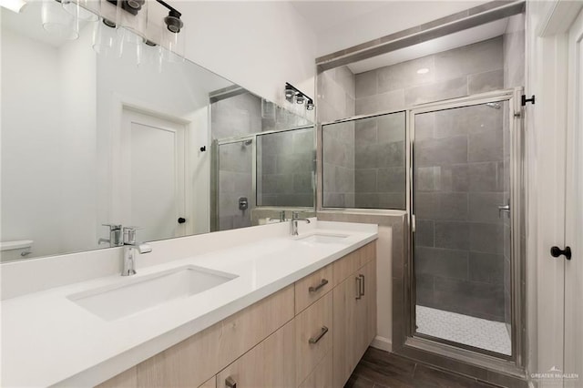 bathroom featuring hardwood / wood-style floors, vanity, and a shower with door