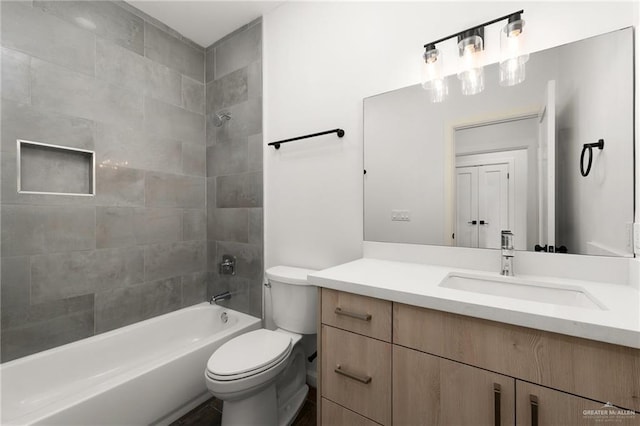 full bathroom with vanity, tiled shower / bath combo, and toilet