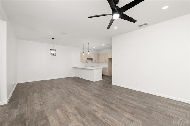 unfurnished living room with dark hardwood / wood-style floors, ceiling fan, and sink