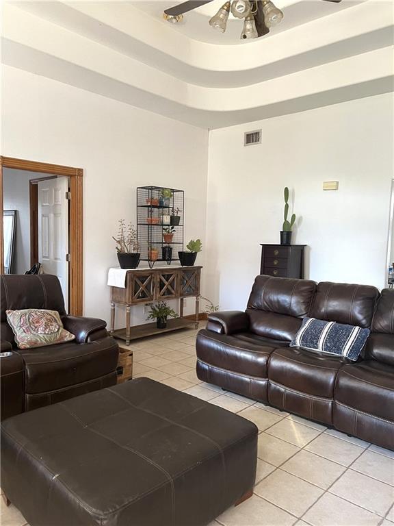 living room with ceiling fan and light tile patterned floors