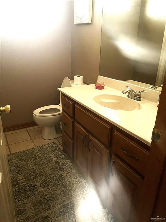 bathroom featuring tile patterned flooring, vanity, and toilet