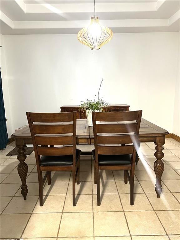 dining space with light tile patterned flooring and a tray ceiling