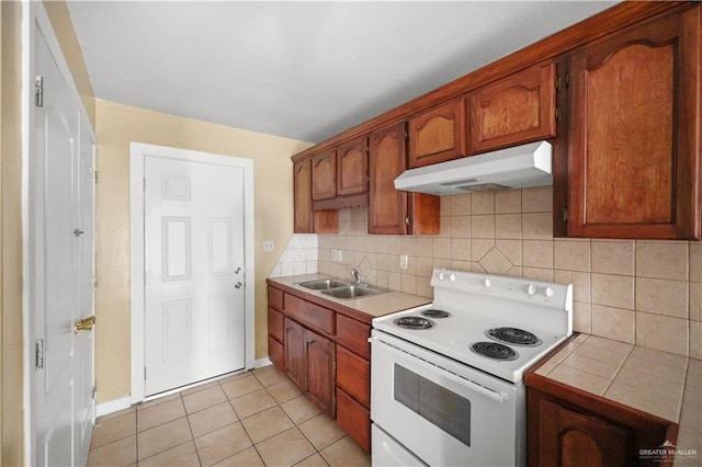 kitchen featuring tile countertops, electric range, backsplash, a sink, and under cabinet range hood