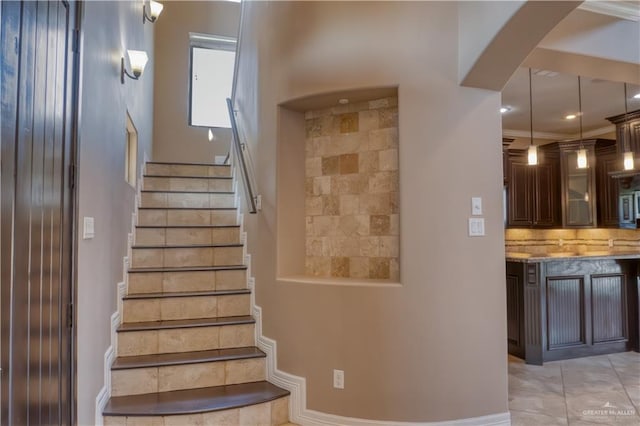 stairway featuring tile patterned floors and ornamental molding