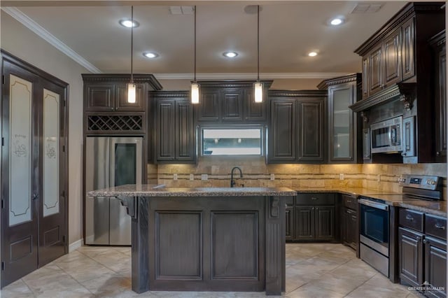 kitchen featuring pendant lighting, a kitchen island, appliances with stainless steel finishes, and dark stone counters