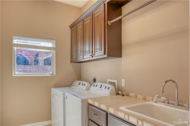 laundry area featuring a healthy amount of sunlight, cabinets, independent washer and dryer, and sink