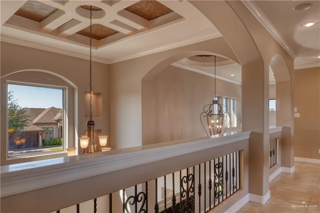 corridor with coffered ceiling, an inviting chandelier, beamed ceiling, light tile patterned floors, and ornamental molding