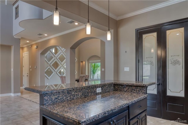 kitchen featuring decorative light fixtures, a center island, and crown molding