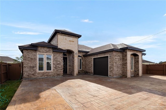 view of front of property featuring a garage and a patio