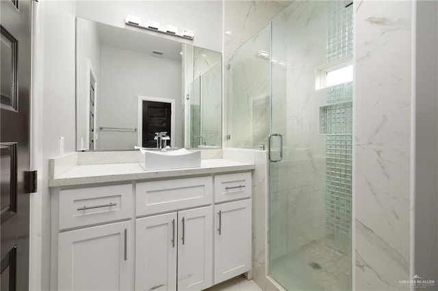 bathroom featuring vanity and a shower with shower door