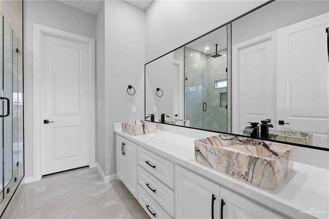 bathroom featuring a shower with door and vanity