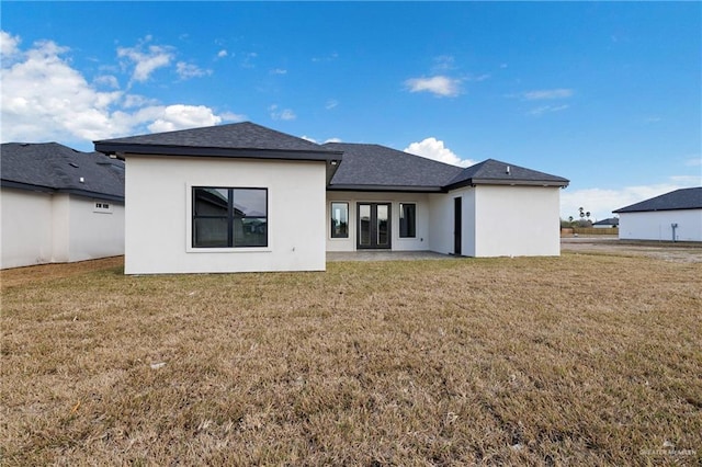 back of house with a lawn and a patio