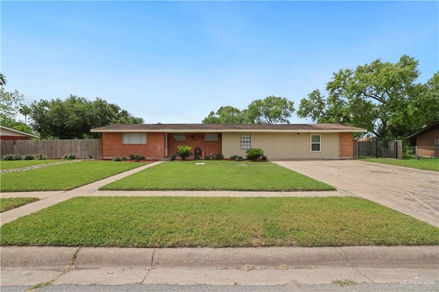 single story home with driveway, fence, a front lawn, and brick siding