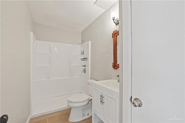 full bathroom with a shower, wood finished floors, vanity, and toilet