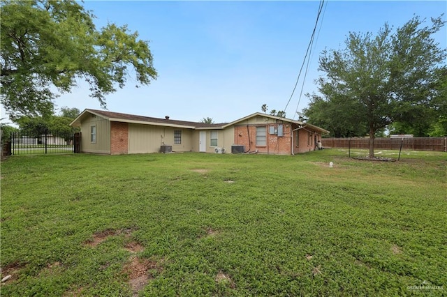 exterior space with brick siding, fence, and a lawn