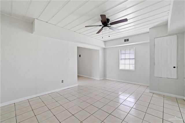 empty room featuring visible vents, ceiling fan, light tile patterned flooring, and baseboards