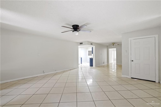 unfurnished room with ceiling fan, light tile patterned floors, a textured ceiling, visible vents, and baseboards