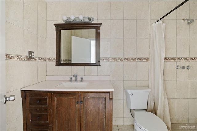 bathroom with toilet, tile walls, tiled shower, and vanity