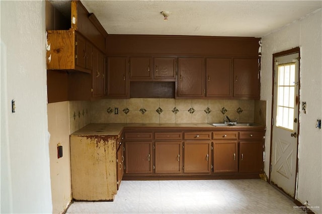 5909 S Kountry Loop, Mission, TX 78574 - kitchen with tasteful backsplash, a sink, and brown cabinetry