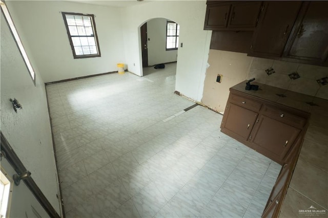 5909 S Kountry Loop, Mission, TX 78574 - kitchen featuring arched walkways, light floors, dark brown cabinetry, and baseboards