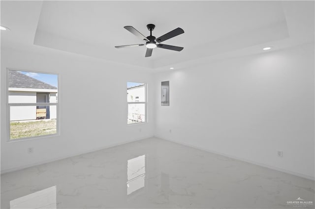 unfurnished room with marble finish floor, a raised ceiling, and recessed lighting