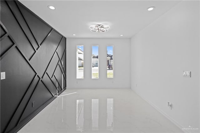 unfurnished room with baseboards, marble finish floor, and recessed lighting