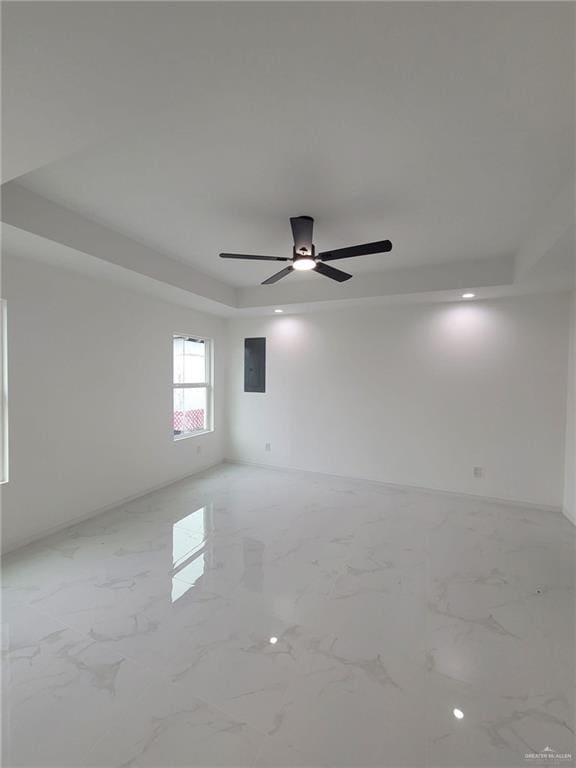 unfurnished room with a raised ceiling and ceiling fan