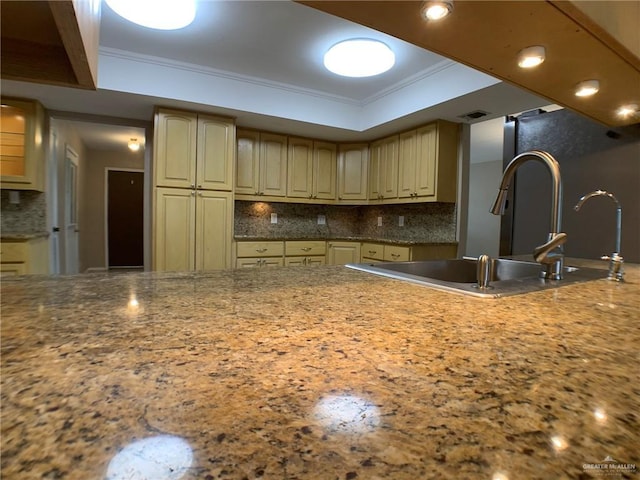 1802 N 17th St, Harlingen, TX 78550 - kitchen featuring crown molding, backsplash, a tray ceiling, light stone counters, and cream cabinets