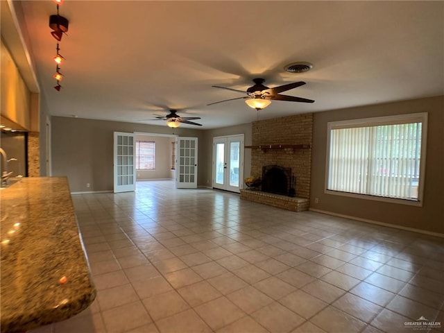 1802 N 17th St, Harlingen, TX 78550 - unfurnished living room with light tile patterned flooring, french doors, ceiling fan, and a fireplace