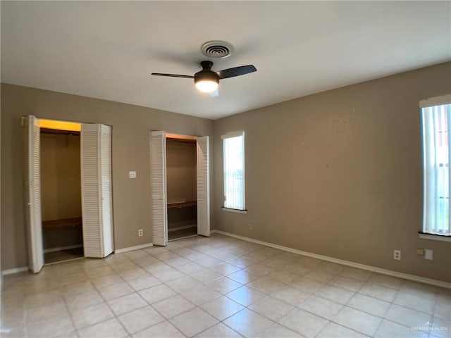 1802 N 17th St, Harlingen, TX 78550 - unfurnished bedroom featuring multiple closets, multiple windows, and ceiling fan