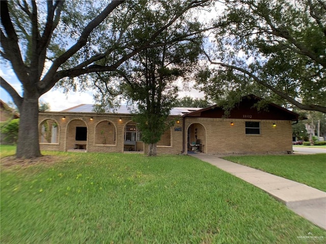 1802 N 17th St, Harlingen, TX 78550 - single story home with a front yard, roof mounted solar panels, and brick siding