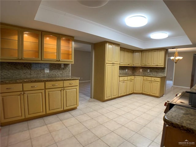 1802 N 17th St, Harlingen, TX 78550 - kitchen with a tray ceiling, decorative backsplash, glass insert cabinets, a chandelier, and light tile patterned floors