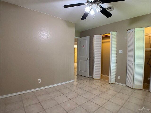 1802 N 17th St, Harlingen, TX 78550 - unfurnished bedroom featuring multiple closets, light tile patterned floors, and ceiling fan