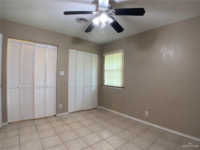 1802 N 17th St, Harlingen, TX 78550 - unfurnished bedroom with multiple closets, a ceiling fan, and light tile patterned flooring