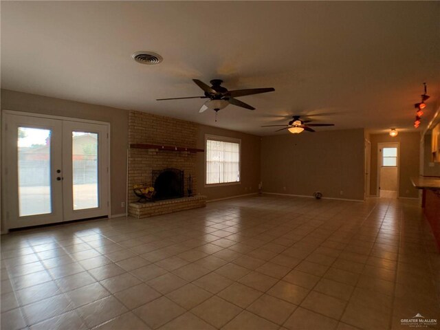 1802 N 17th St, Harlingen, TX 78550 - unfurnished living room with light tile patterned flooring, french doors, ceiling fan, and a brick fireplace