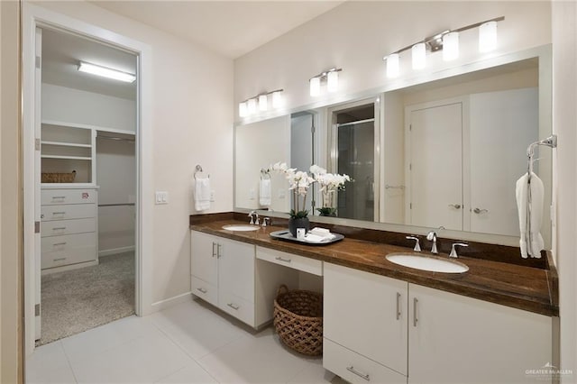 bathroom featuring tile patterned flooring, vanity, and walk in shower