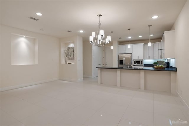 kitchen with pendant lighting, an inviting chandelier, white cabinets, light tile patterned floors, and appliances with stainless steel finishes