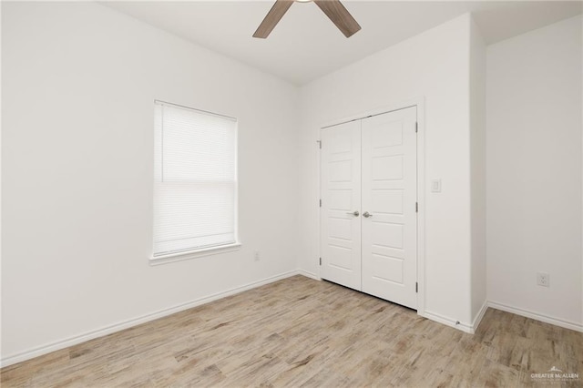 unfurnished bedroom with ceiling fan, a closet, and light wood-type flooring