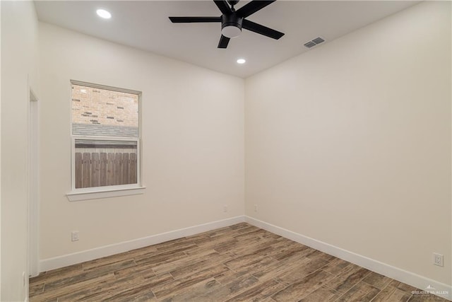 unfurnished room featuring recessed lighting, wood finished floors, visible vents, and baseboards