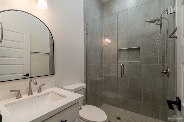 bathroom with vanity, toilet, and a stall shower