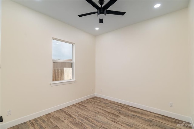 spare room featuring a ceiling fan, recessed lighting, wood finished floors, and baseboards