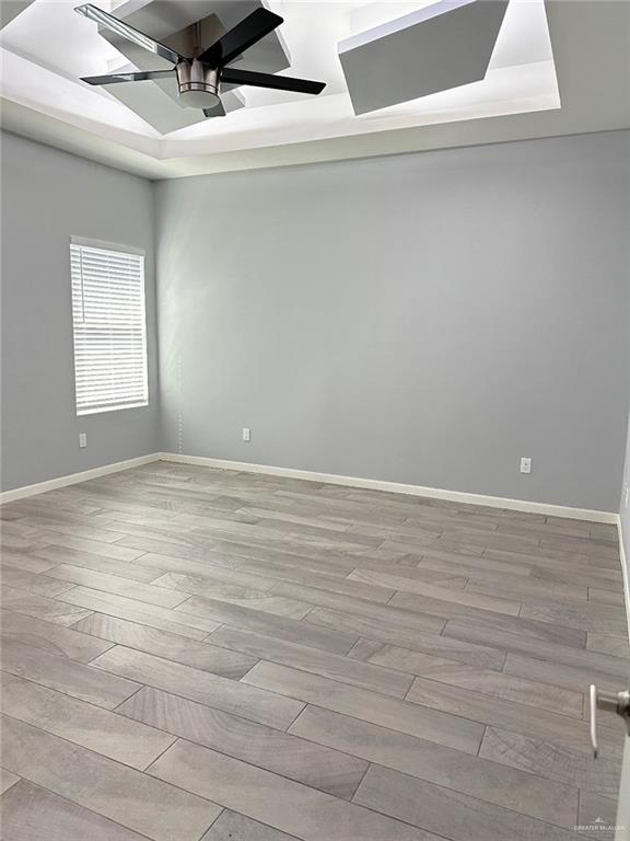 unfurnished room featuring ceiling fan, baseboards, and wood finished floors