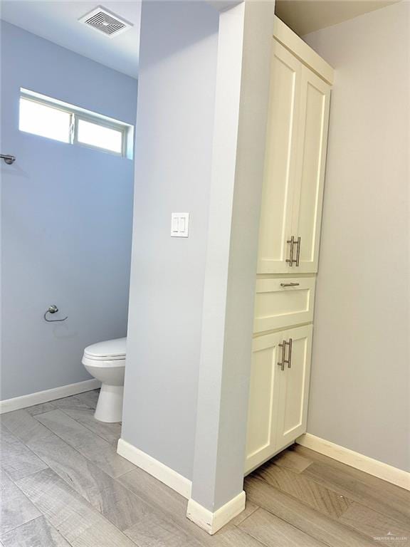 bathroom featuring toilet, baseboards, visible vents, and vanity