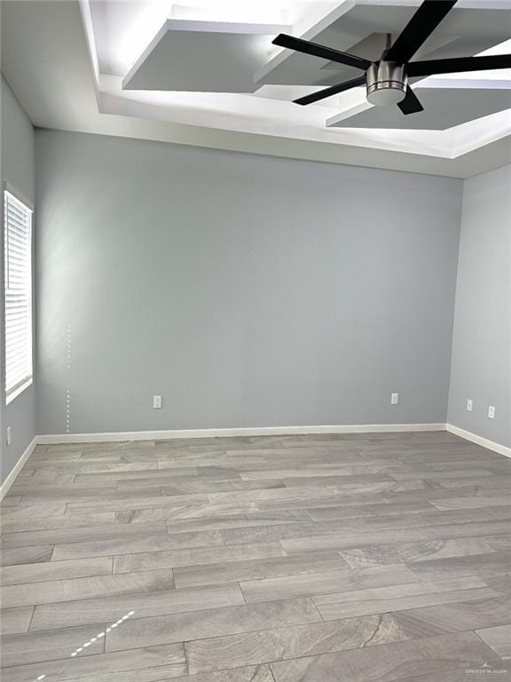 unfurnished room with light wood-type flooring, a ceiling fan, and baseboards