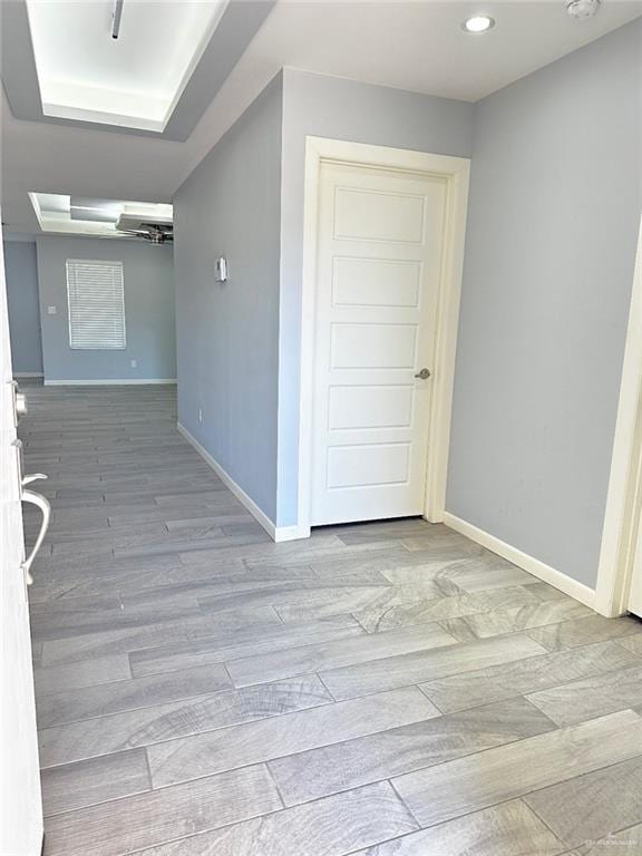 corridor featuring recessed lighting, baseboards, and wood finished floors