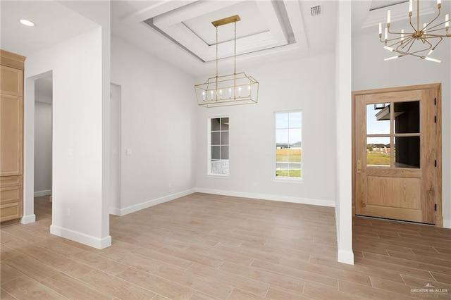 entrance foyer with a tray ceiling and a notable chandelier