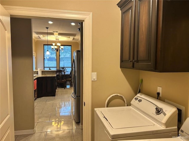 laundry area featuring cabinets, a chandelier, and washing machine and clothes dryer