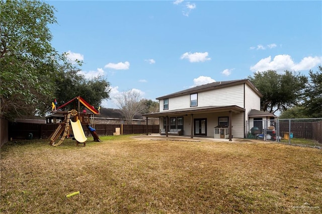 rear view of house with a yard, a patio, and a playground