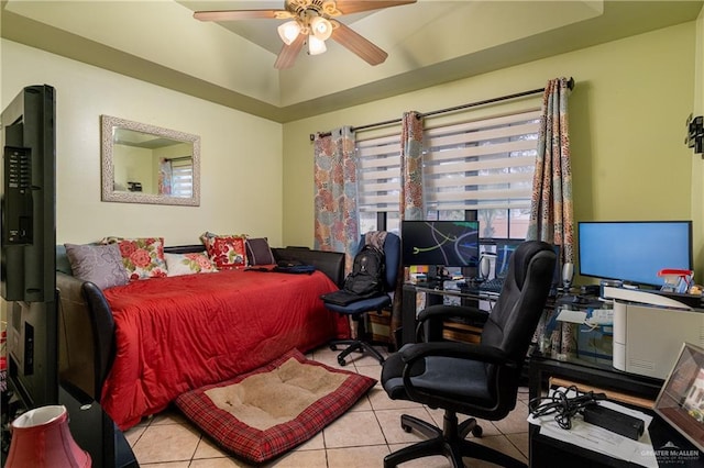 bedroom featuring light tile patterned floors, ceiling fan, and a raised ceiling